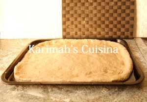PIZZA DOUGH SPREAD ON OILED TRAY